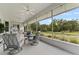 Enclosed lanai with multiple seating areas and a view of the grassy and landscaped backyard at 6442 Bendelow Dr, Lakeland, FL 33810