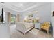 Bright main bedroom featuring a tray ceiling, neutral carpet and private balcony access at 6442 Bendelow Dr, Lakeland, FL 33810