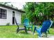 Secluded backyard seating area featuring colorful Adirondack chairs and lush greenery at 1820 N Merrick Dr, Deltona, FL 32738