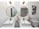 Well-lit bathroom featuring modern fixtures, dual sinks, and stylish mirrors at 1820 N Merrick Dr, Deltona, FL 32738