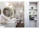 Modern bathroom with dual vanity, brass fixtures, and a glass-enclosed shower at 1820 N Merrick Dr, Deltona, FL 32738
