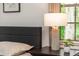Relaxing bedroom features a nightstand with lamp and a large window at 1820 N Merrick Dr, Deltona, FL 32738