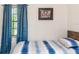 Bright bedroom with a blue and white striped bedspread and artwork on the wall at 1820 N Merrick Dr, Deltona, FL 32738