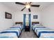 Guest bedroom features twin beds, soft lighting, and calming blue decor for a peaceful stay at 1820 N Merrick Dr, Deltona, FL 32738