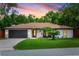 Charming single-story home features a well-maintained lawn, and an attached two-car garage at 1820 N Merrick Dr, Deltona, FL 32738