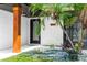 Charming entryway of home featuring a black door, wooden post and meticulous landscaping at 1820 N Merrick Dr, Deltona, FL 32738