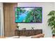 Living room displaying a large TV mounted on the wall with plants nearby at 1820 N Merrick Dr, Deltona, FL 32738