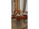 Elegant dining room features a glass-top table, modern orange chairs, and soft natural light at 153 Tigerlily Ct, Davenport, FL 33837