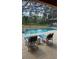 Relaxing poolside scene featuring comfortable lounge chairs and scenic views beyond the screened enclosure at 153 Tigerlily Ct, Davenport, FL 33837