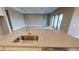 Close-up of a kitchen island with a stainless steel sink and faucet, set against an open living area at 5653 Nevis Ter, Kissimmee, FL 34758