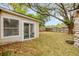 Fenced backyard with a grassy area, stone accents, and mature trees at 110 E Lauren Ct, Fern Park, FL 32730