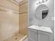 Bathroom featuring a shower, a gray vanity, and a round mirror at 110 E Lauren Ct, Fern Park, FL 32730
