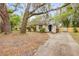 Charming single-story home with a black front door, mature trees, and a long driveway at 110 E Lauren Ct, Fern Park, FL 32730