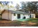 View of the rear exterior featuring sliding glass doors leading to a green patio with an A/C unit at 20732 Sw Marine Blvd, Dunnellon, FL 34431