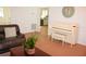 Bright living room featuring a white piano with bench and a view into the kitchen at 20732 Sw Marine Blvd, Dunnellon, FL 34431