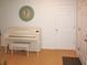 Clean and bright living room with a white piano, clock, and a view of the front door at 20732 Sw Marine Blvd, Dunnellon, FL 34431