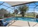 Inviting screened-in pool area with comfortable lounge chairs and serene views of the surrounding water at 460 Tess Ct, Orlando, FL 32834