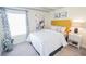 Cozy bedroom with bright white linen and chic decor, including a sunny yellow headboard at 5884 Meditation Dr, Clermont, FL 34714