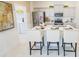 Modern kitchen featuring an island with seating, stainless steel appliances, and white cabinets at 5884 Meditation Dr, Clermont, FL 34714