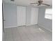 Bedroom with two closets, tile floors, a ceiling fan and natural light from a window at 5932 Hilltop E Ln, Lakeland, FL 33809