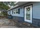 Close up of a charming single story home with blue painted wood siding and decorative wreath and welcome mat at 5932 Hilltop E Ln, Lakeland, FL 33809