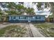 Charming single story home with blue painted wood siding and a walkway to the front door and manicured lawn at 5932 Hilltop E Ln, Lakeland, FL 33809