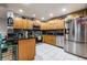 Modern kitchen with stainless steel appliances, wooden cabinetry, granite countertops, and tile backsplash at 5932 Hilltop E Ln, Lakeland, FL 33809