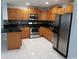 Kitchen features stainless steel appliances, wood cabinets, granite counters, and tile backsplash at 5932 Hilltop E Ln, Lakeland, FL 33809