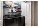 Bright laundry room features black front load washer and dryer along with wire shelves for storage at 5932 Hilltop E Ln, Lakeland, FL 33809
