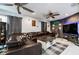 Spacious living room features two ceiling fans, tile floors, large leather sofa, and accent wall at 5932 Hilltop E Ln, Lakeland, FL 33809
