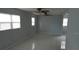 Bright living room with tile floors, ceiling fans, and plenty of natural light from multiple windows at 5932 Hilltop E Ln, Lakeland, FL 33809