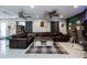 Spacious living room features two ceiling fans, tile floors, large leather sofa, and accent wall at 5932 Hilltop E Ln, Lakeland, FL 33809