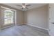 Neutrally painted bedroom with light gray floors, ceiling fan and an arched window at 2769 Corrigan Dr, Deltona, FL 32738