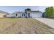 Traditional home with neutral color palette, two-car garage, arched windows, and an expansive front yard at 2769 Corrigan Dr, Deltona, FL 32738