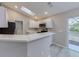Modern kitchen with stainless steel appliances, a breakfast bar, and a sliding door to the backyard at 2769 Corrigan Dr, Deltona, FL 32738