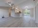 Open-concept living area with gray wood flooring, a ceiling fan, and a view into the kitchen at 2769 Corrigan Dr, Deltona, FL 32738