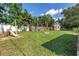 View of the grassy backyard including a playset, shed, landscaping and wooden fence at 4821 S Gachet Blvd, Lakeland, FL 33813