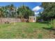 Backyard featuring a wood storage shed, green grass, a wood fence and mature trees at 4821 S Gachet Blvd, Lakeland, FL 33813