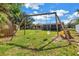 Swing set in the grassy backyard with mature trees on a sunny day at 4821 S Gachet Blvd, Lakeland, FL 33813