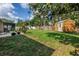 Backyard with a large shade tree, green grass, a wood fence and a storage shed at 4821 S Gachet Blvd, Lakeland, FL 33813