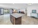 Kitchen island with light granite top, dark wood cabinets, and open floorplan to the dining room and outdoor patio at 4821 S Gachet Blvd, Lakeland, FL 33813