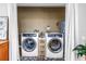 Laundry room featuring newer front-loading washer and dryer and white privacy curtains at 4821 S Gachet Blvd, Lakeland, FL 33813