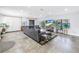 Bright living room with large gray sectional sofa, tile floors, and view through the large window at 4821 S Gachet Blvd, Lakeland, FL 33813