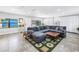 Bright living room with large gray sectional sofa, tile floors, bright windows, and a front entry at 4821 S Gachet Blvd, Lakeland, FL 33813