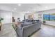 Spacious living room featuring tile floors, a large sectional sofa, and bright windows at 4821 S Gachet Blvd, Lakeland, FL 33813
