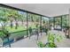 View of the screened porch with patio furniture and many plants overlooking a backyard with a wooden fence and landscaping at 4821 S Gachet Blvd, Lakeland, FL 33813