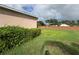 Large backyard with lush green lawn, privacy landscaping, and a brick fence at 2163 Wintermere Pointe Dr, Winter Garden, FL 34787