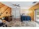 Comfortable bedroom with wood paneling, ceiling fan, and access to the outdoors at 25302 Lido Ave, Sorrento, FL 32776