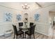 Charming dining area with modern chandelier, wood floors, wainscotting, and views to kitchen and living room at 25302 Lido Ave, Sorrento, FL 32776