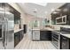 Modern kitchen featuring dark cabinetry, stainless steel appliances, light countertops, and updated flooring at 25302 Lido Ave, Sorrento, FL 32776